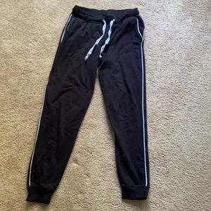 Black joggers with white stripe down the legs.